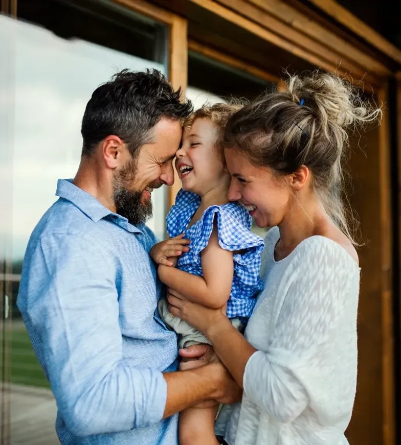 Happy family playing outdoors, parents with child in nature
